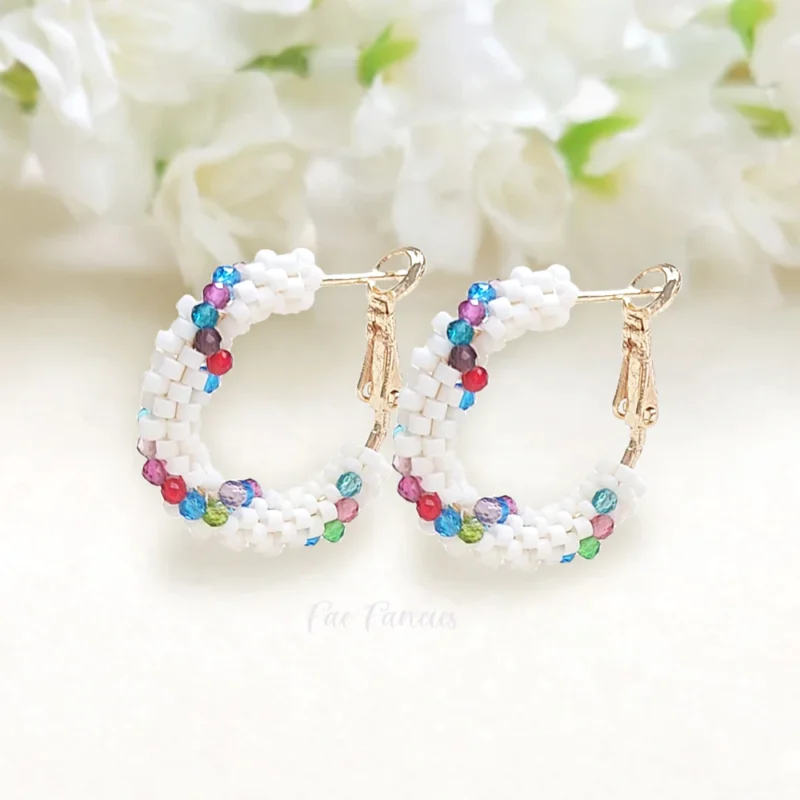 Handmade beaded hoop earrings by Fae Fancies, white color with multicolored glass beads weaved around, Spiral Collection